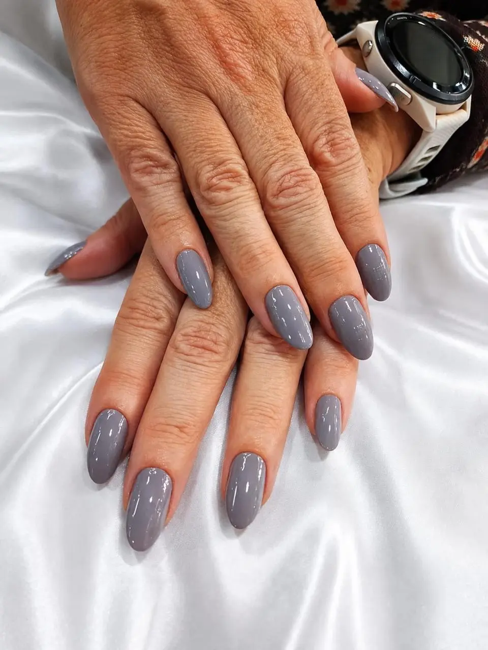 Manicure com esmaltação cinza realizada no salão